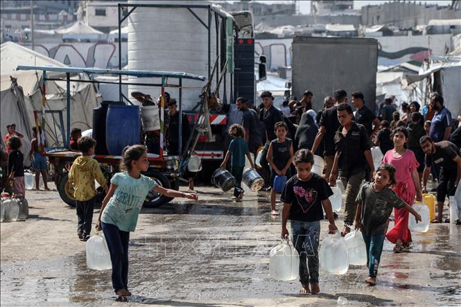 Trẻ em Palestine lấy nước tại điểm cấp nước công cộng ở Gaza. Ảnh: THX/TTXVN phát
