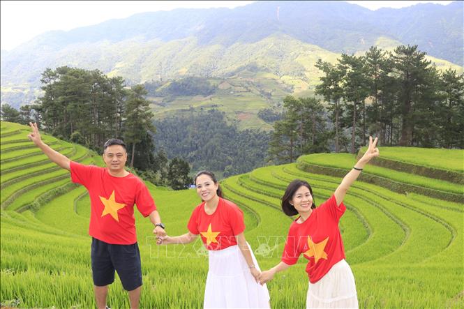 Gia đình anh Lê Nguyên Việt ở Hải Phòng tranh thủ chụp ảnh lưu lại kỷ niệm khi đến võng lúa Mù Cang Chải. Ảnh: Tuấn Anh - TTXVN