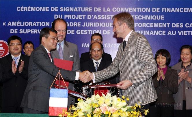  Đại diện Ngân hàng Nhà nước Việt Nam, Cơ quan Phát triển Pháp (AFD) và Đại sứ quán Pháp ký kết khoản viện trợ không hoàn lại trị giá 1 triệu Euro của Pháp giúp Việt Nam thực hiện dự án hỗ trợ kỹ thuật “Hoàn thiện khuôn khổ pháp lý và tăng cường năng lực quản lý, giám sát cho lĩnh vực tài chính vi mô tại Việt Nam” (Hà Nội, 13/12/2011). Ảnh: Trần Việt - TTXVN