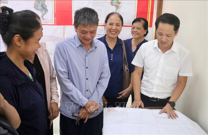Chủ tịch UBND xã Vĩnh Thanh Nguyễn Quang Đặng trao đổi với người dân về thông tin điều chỉnh quy hoạch. Ảnh: Nguyễn Thắng - TTXVN