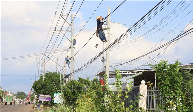 Công nhân thực hiện tháo dỡ, sắp xếp lại hệ thống dây dẫn trên các trụ điện, phục vụ di dời đường điện trong phạm vi dự án nâng cấp, mở rộng tuyến đường tỉnh 753. Ảnh: Đậu Tất Thành – TTXVN