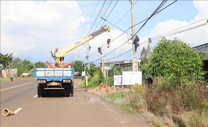 Đơn vị thi công triển khai di dời hệ thống đường dây, trụ điện trên tuyến đường tỉnh 753, phục vụ dự án nâng cấp, mở rộng tuyến đường. Ảnh: Đậu Tất Thành – TTXVN