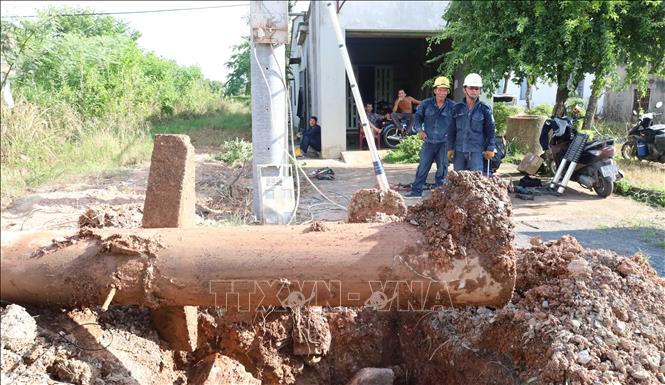 Trụ điện cũ được đào lên khỏi hố móng để di dời, phục vụ thi công dự án nâng cấp, mở rộng tuyến đường tỉnh 753. Ảnh: Đậu Tất Thành – TTXVN