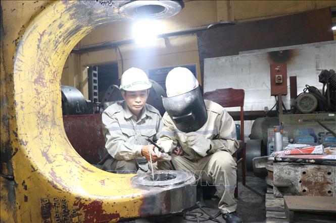Vũ Văn Phong, Tổ trưởng sửa chữa thuộc Xưởng sửa chữa, Công ty Xi măng Hoàng Thạch đang hướng dẫn đồng nghiệp trong thực hiện nhiệm vụ chuyên môn. Ảnh: Mạnh Tú - TTXVN