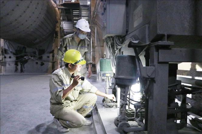 Công nhân kỹ thuật bậc 5/5 Nguyễn Hữu Phước (mũ vàng) đang kiểm tra hệ thống nghiền xi măng tại Xưởng xi măng , Công ty Xi măng Hoàng Thạch 
Ảnh: Mạnh Tú - TTXVN