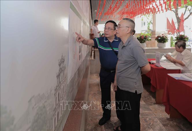 Người dân nghiên cứu kỹ các nội dung đóng góp ý. Ảnh: Phan Phương – TTXVN