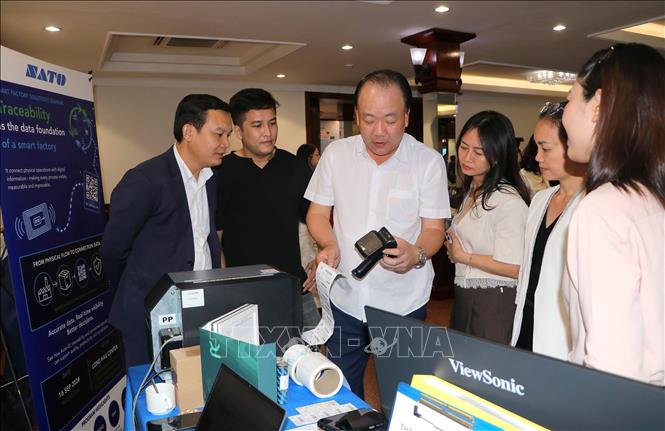 Đại diện Cục Quản lý và Phát triển thị trường trong nước thăm gian hàng trưng bày giải pháp truy xuất nguồn gốc trong khuôn khổ tọa đàm. Ảnh: Thanh Vũ - TTXVN