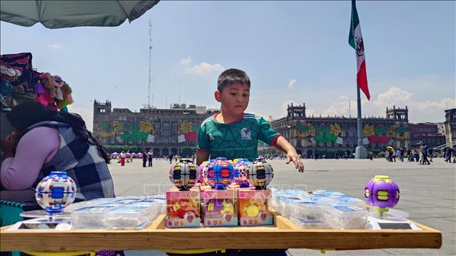 Bé trai người bản địa giúp mẹ bán hàng lưu niệm tại khu vực trung tâm thủ đô Mexico City, Mexico. Ảnh: Phi Hùng - PV TTXVN tại Mexico