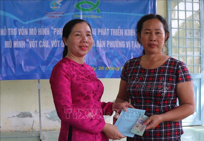 Trao sổ thành viên và nguồn vốn hỗ trợ có hoàn lại cho chị em phụ nữ ở phường Vị Tân. Ảnh: Nguyễn Hằng - TTXVN