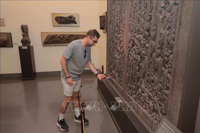 Du khách nước ngoài có thể dễ dàng tự quét mã QR để tìm hiểu chi tiết mọi thông tin về các hiện vật trưng bày tại Bảo tàng Mỹ thuật Việt Nam. Ảnh: Phan Phương – TTXVN