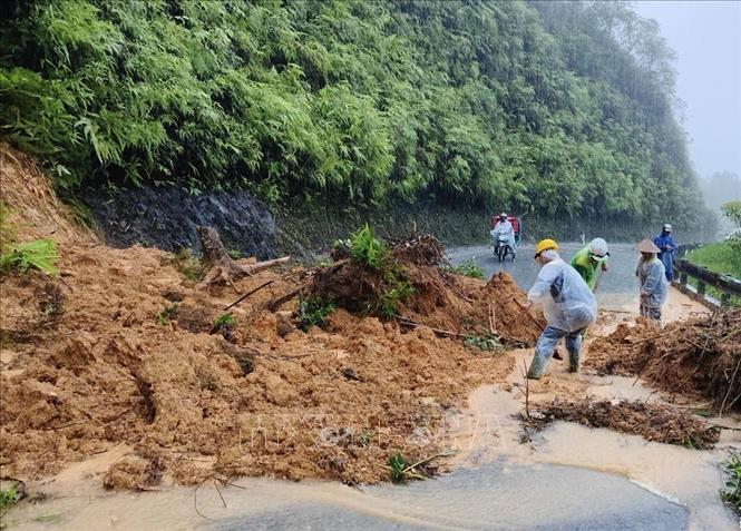 Nhiều người khắc phục sạt lở trên Quốc lộ 49, thành phố Huế. Ảnh: TTXVN phát