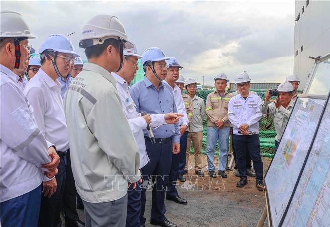 Phó Thủ tướng Thường trực Phạm Gia Túc nghe lãnh đạo PVN báo cáo tiến độ dự án Nhà máy Nhiệt điện Long Phú 1 tại xã Đại Ngãi. Ảnh: Thanh Liêm - TTXVN