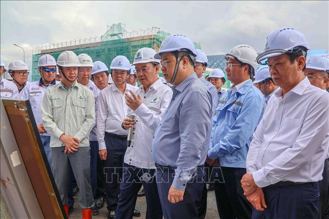 Phó Thủ tướng Thường trực Phạm Gia Túc nghe lãnh đạo PVN báo cáo tiến độ dự án Nhà máy Nhiệt điện Long Phú 1 tại xã Đại Ngãi. Ảnh: Thanh Liêm - TTXVN