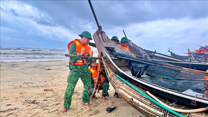 Bộ đội biên phòng thành phố Huế giúp dân gia cố tàu thuyền. Ảnh: Mai Trang - TTXVN 