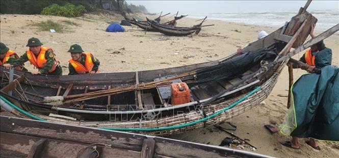 Bộ đội biên phòng thành phố Huế giúp dân gia cố tàu thuyền. Ảnh: Mai Trang - TTXVN 