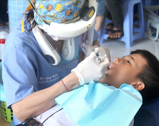 Đội ngũ y bác sĩ tận tình thăm khám, tư vấn và hướng dẫn cách chăm sóc răng miệng cho trẻ em. Ảnh: Hồng Hiếu - TTXVN