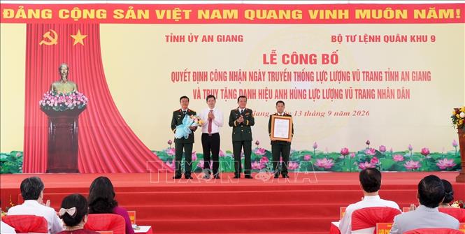 Trung Tướng Hồ Văn Thái, Bí thư Đảng ủy, Chính ủy Quân khu 9 và đồng chí Lê Quang Tùng, Ủy viên BCH Trung ương Đảng, Bí thư Tỉnh ủy tỉnh An Giang trao Quyết định công nhận ngày truyền thống lực lượng vũ trang tỉnh An Giang và tặng hoa chúc mừng. Ảnh: Lê Huy Hải - TTXVN