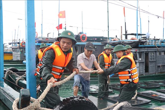 Lực lượng bộ đội biên phòng thành phố Huế kêu gọi, hỗ trợ ngư dân neo đậu tàu thuyền an toàn. Ảnh: Mai Trang- TTXVN