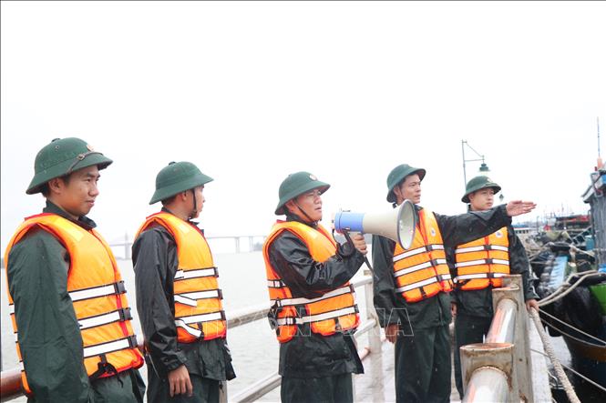 Lực lượng bộ đội biên phòng thành phố Huế kêu gọi, hỗ trợ ngư dân neo đậu tàu thuyền an toàn. Ảnh: Mai Trang- TTXVN