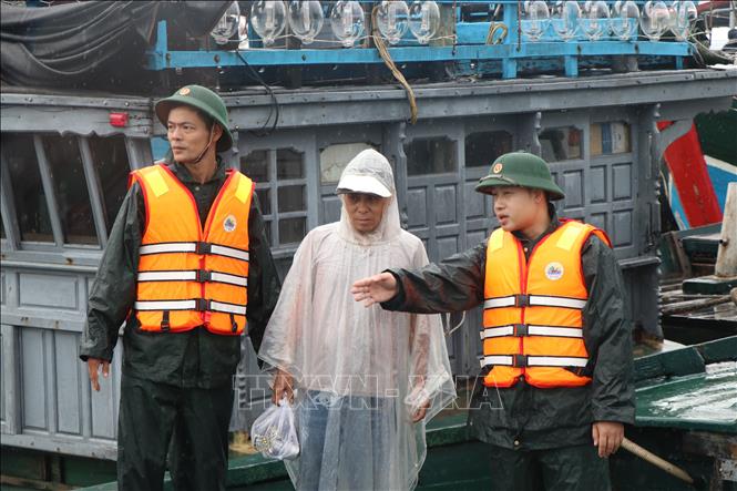 Lực lượng bộ đội biên phòng thành phố Huế kêu gọi, hỗ trợ ngư dân neo đậu tàu thuyền an toàn. Ảnh: Mai Trang- TTXVN