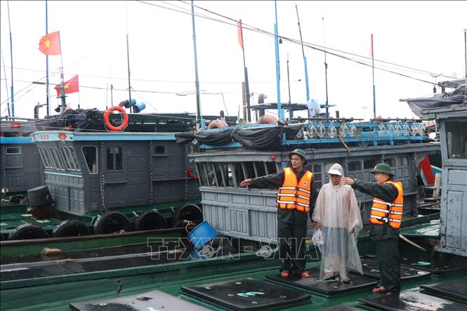 Lực lượng bộ đội biên phòng thành phố Huế kêu gọi, hỗ trợ ngư dân neo đậu tàu thuyền an toàn. Ảnh: Mai Trang- TTXVN
