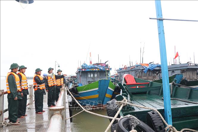 Lực lượng bộ đội biên phòng thành phố Huế kêu gọi, hỗ trợ ngư dân neo đậu tàu thuyền an toàn. Ảnh: Mai Trang- TTXVN