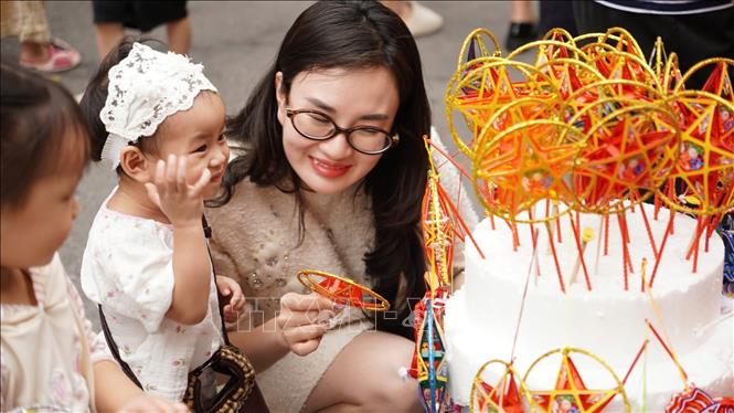 Một em nhỏ thích thú lựa chọn đèn ông sao - món đồ chơi quen thuộc mỗi dịp Tết Trung thu. Ảnh: Nguyên Hiếu - TTXVN