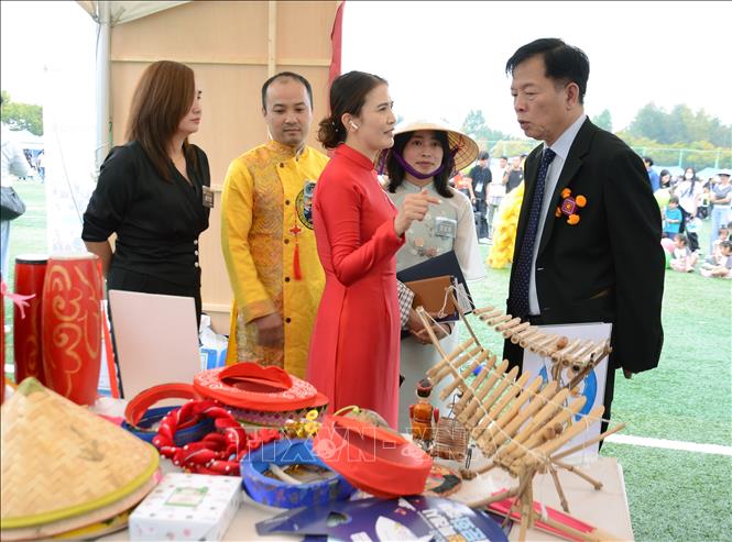 Bà Nguyễn Thị Phúc - Chủ tịch Chi hội người Việt Nam tại thành phố Hwaseong giới thiệu với Đại sứ Vũ Hồ về gian hàng Việt Nam tại Lễ hội. Ảnh: Trường Giang - Pv TTXVN tại Hàn Quốc