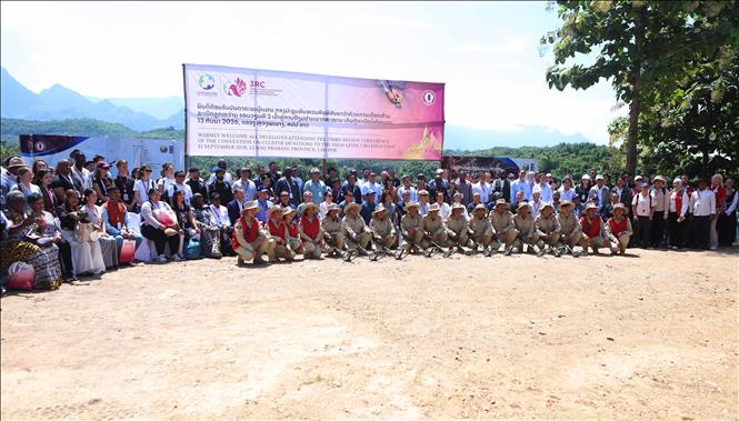Các đại biểu tham dự sự kiện chụp ảnh cùng Đội rà phá bom mìn trên địa bàn tỉnh Luang Prabang. Ảnh: Xuân Tú - PV TTXVN tại Lào