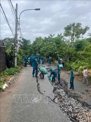 Chính quyền địa phương và các lực lượng chức năng tiến hành vận chuyển và xếp bao tải cát để hạn chế sạt lở tiếp tục lan rộng, ảnh hưởng đến công trình và an toàn của người dân tại khu vực xung yếu. Ảnh: TTXVN phát