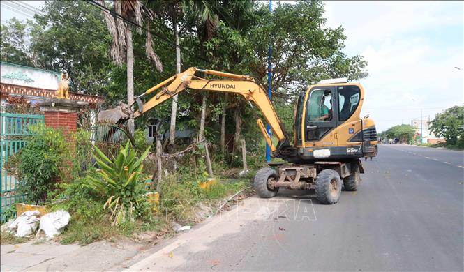 Máy móc được huy động tháo dỡ các hạng mục công trình nằm trong phạm vi giải phóng mặt bằng dự án cao tốc Gia Nghĩa - Chơn Thành. Ảnh: Đậu Tất Thành - TTXVN 