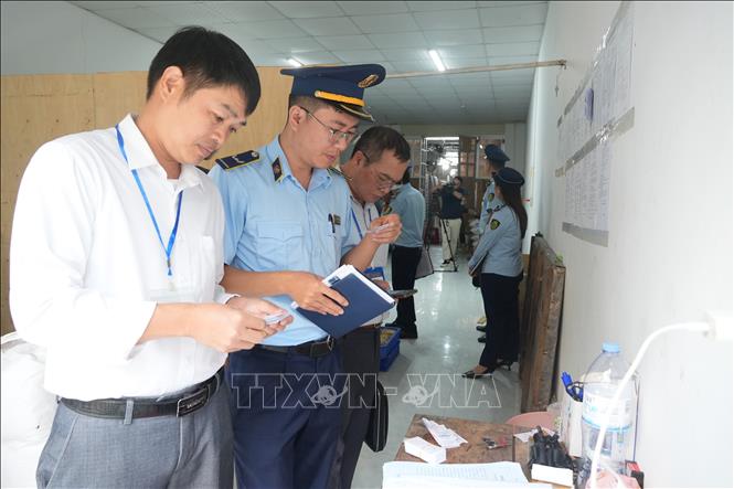 Các cán bộ đang kiểm tra thông số kỹ thuật tại cơ sở bánh trung thu ở Lạng Sơn. Ảnh: Tiến Vĩnh -TTXVN
