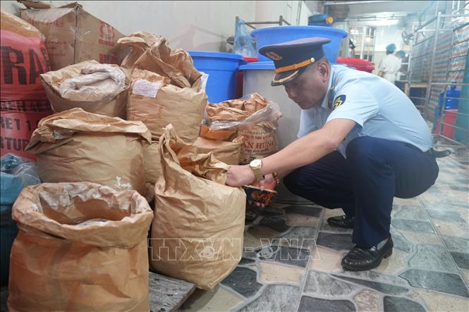 Quản lý thị trường kiểm tra xuất xứ nguyên liệu sản xuất bánh trung thu. Ảnh: Tiến Vĩnh –TTXVN