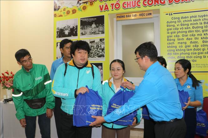 Lãnh đạo Trung tâm Tư vấn và Hỗ trợ người lao động Công đoàn Thành phố Hồ Chí Minh tặng qua cho các tài xế xe công nghệ có hoàn cảnh khó khăn. Ảnh: Thanh Vũ - TTXVN