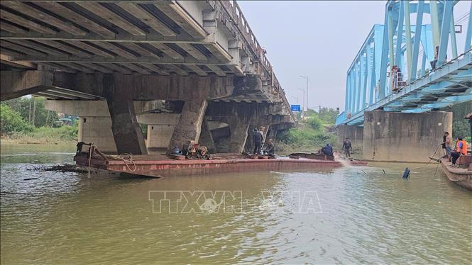 Sà lan bị chìm tại chân cầu Mỹ Chánh đã được lực lượng cứu hộ trục vớt. Ảnh: Nguyên Linh - TTXVN