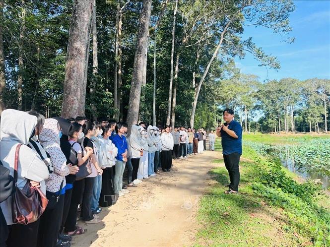 Em Sơn Trần Minh Mẫn (bên phải), trưởng nhóm dự án SABAY giới thiệu di sản văn hóa địa phương với sinh viên Đại học Trà Vinh trong khuôn khổ dự án SABAY. Ảnh: TTXVN phát