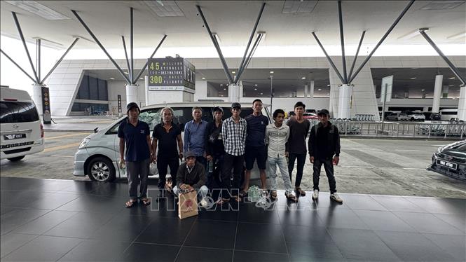 Nhóm 10 ngư dân được được cán bộ Đại sứ quán đưa ra sân bay, làm thủ tục trở về Việt Nam an toàn. Ảnh: TTXVN phát
