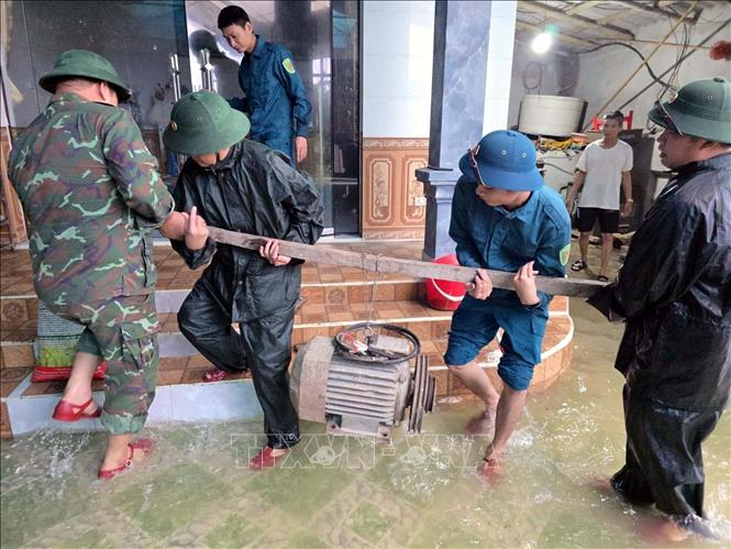 Lực lượng dân quân phối hợp với địa phương tổ chức vận chuyển đồ đạc, tài sản của các hộ dân đến nơi an toàn. Ảnh: Đại Nghĩa - TTXVN