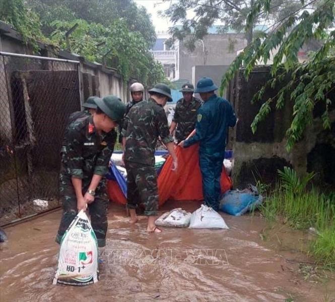 Ban quân sự Phường Hà Nam tham gia giúp dân chằng chống nhà cửa, di chuyển tài sản đến nơi an toàn, kết hợp khơi thông dòng chảy, xử lý triệt để các điểm ngập úng, gia cố các vị trí xung yếu và thực hiện nhiệm vụ cứu hộ, cứu nạn khi có yêu cầu. Ảnh: Đại Nghĩa - TTXVN