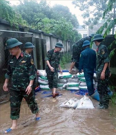 Ban quân sự Phường Hà Nam tham gia giúp dân chằng chống nhà cửa, đi chuyển tài sản đến nơi an toàn, kết hợp khơi thông dòng chảy, xử lý triệt để các điểm ngập úng, gia cố các vị trí xung yếu và thực hiện nhiệm vụ cứu hộ, cứu nạn khi có yêu cầu. Ảnh: Đại Nghĩa - TTXVN