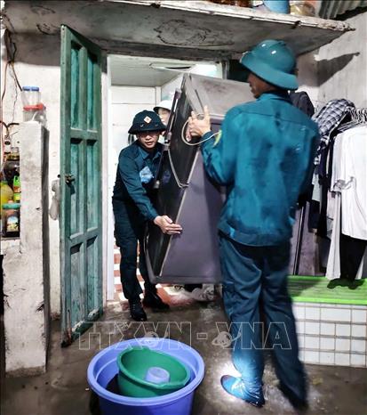 Ban quân sự Phường Châu Sơn tham gia giúp dân di chuyển đồ đạc đến nơi an toàn do mưa ngập khu vực sông Đáy. Ảnh: Đại Nghĩa - TTXVN