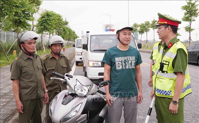 Tuyên truyền, vận động người tham gia giao thông chấp hành các quy định về bảo đảm an toàn khi lưu thông tại khu công nghiệp Liên Hà Thái. Ảnh: Nguyễn Công Hải - TTXVN 