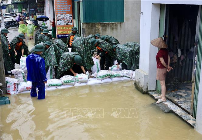 Lực lượng bộ đội hỗ trợ đắp đê bao ngăn nước khu dân cư ven sông Bùi. Ảnh: Nhật Anh - TTXVN