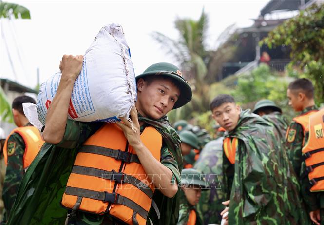 Lực lượng bộ đội hỗ trợ đắp đê bao ngăn nước khu dân cư ven sông Bùi. Ảnh: Nhật Anh - TTXVN