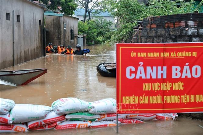 Cán bộ, chiến sĩ Trung đoàn 102, Sư đoàn 308 làm nhiệm vụ tại khu vực bị ngập sâu. Ảnh: Phạm Tuấn Anh - TTXVN