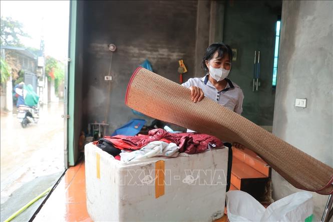 Người dân thôn Ninh Kiều (xã Quảng Bị) kê đồ dùng lên vị trí cao phòng nước dâng. Ảnh: Minh Quyết - TTXVN