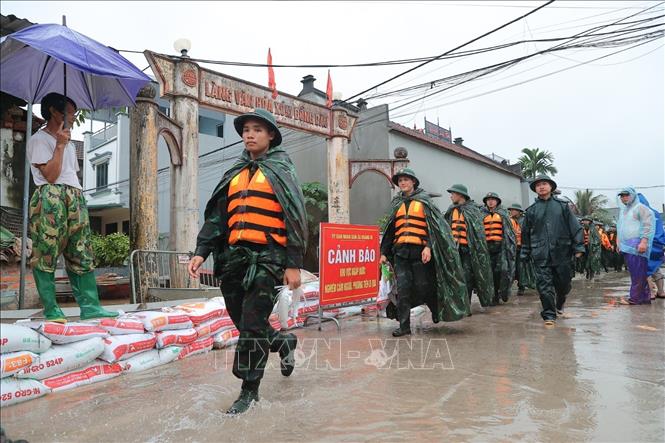 Cán bộ, chiến sĩ Trung đoàn 12, Sư đoàn 308 hỗ trợ đắp đê khu vực thôn Ninh Kiều (xã Quảng Bị). Ảnh: Minh Quyết - TTXVN