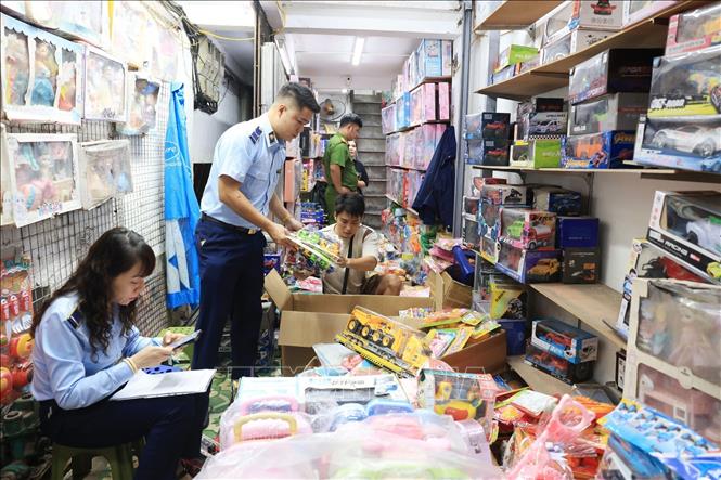 Lực lượng chức năng kiểm tra đồ chơi trẻ em tại cửa hàng số 3B Đồng Xuân. Ảnh: Trần Việt - TTXVN