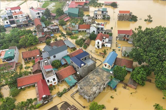 Một khu dân cư bị cô lập giữa vùng nước lũ mênh mông tại xã Quảng Bị. Ảnh: Phạm Tuấn Anh - TTXVN