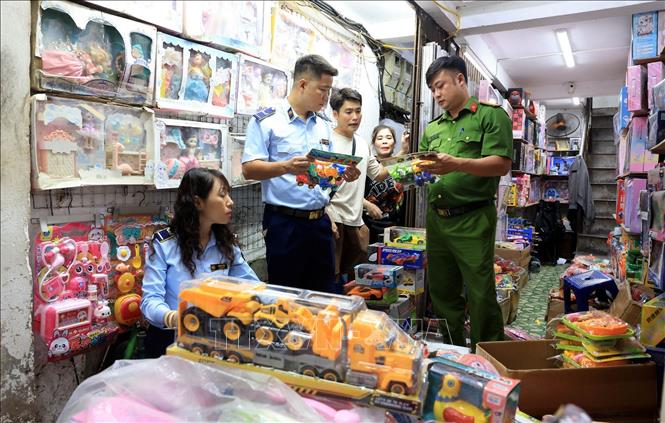 Lực lượng chức năng kiểm tra đồ chơi trẻ em tại cửa hàng số 3B Đồng Xuân. Ảnh: Trần Việt - TTXVN